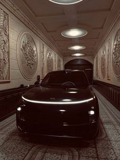 a black car is parked in a long hallway