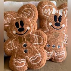 three brown teddy bears sitting on top of a bed next to each other with faces drawn on them