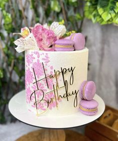 a birthday cake decorated with pink and white flowers