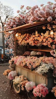 a flower stand with lots of pink and white flowers