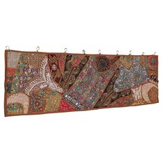 an embroidered wall hanging with elephants and other items on it's sides, in various colors