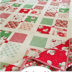 a red and green quilt on top of a wooden table