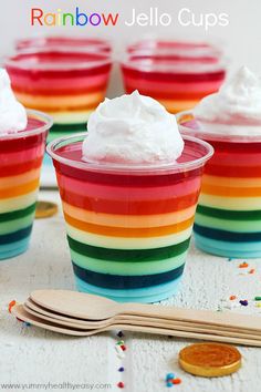 rainbow jello cups with whipped cream and sprinkles on the top are ready to be eaten