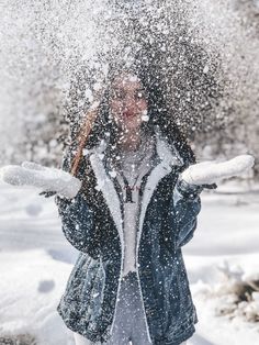 a woman is throwing snow in the air