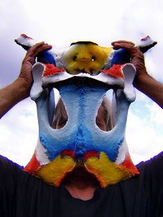 a man is holding his face painted like a bird with two different colors on it