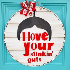 a wooden sign that says i love your stinkin'guts on the front door