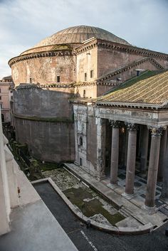 an old building with columns in front of it and a dome on the top floor