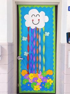 a door decorated to look like a cloud and rainbow streamers with a smiling face on it