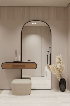 a bathroom with a mirror, stool and vase on the floor in front of it