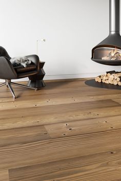 a living room with wood flooring and a fire place in the middle of it