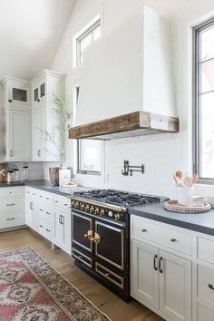 a kitchen with an oven, stove and rug on the floor in front of it