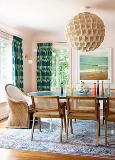 the dining room table is surrounded by wicker chairs and an area rug that matches the wall