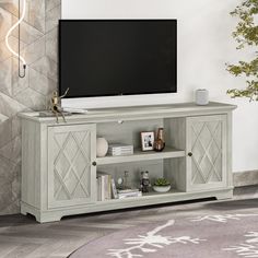 a flat screen tv sitting on top of a wooden entertainment center in a living room