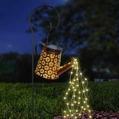 a light up watering can in the grass