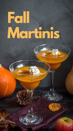 two glasses filled with fall martinis on top of a table