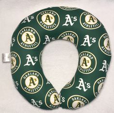 a green and gold neck pillow with the letter a on it's front side