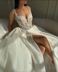 a woman sitting on top of a couch wearing a white dress and high heeled shoes