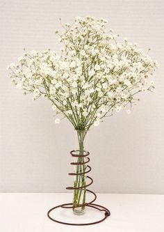 a vase filled with white flowers sitting on top of a table