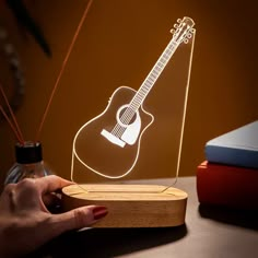 a person holding an illuminated guitar on top of a table