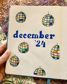 someone holding a notebook with the words december 24 written in blue and multicolored squares