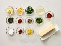 several bowls with different types of food in them on a white counter top next to a piece of wax paper