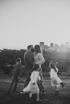 a man and two children are playing in the grass with their arms around each other