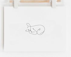 a drawing of a baby laying on top of a white sheet with a wooden clip