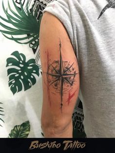 a man's arm with a compass tattoo on it and the words bushabo tattoo