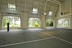 an empty tennis court with lots of windows