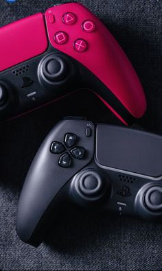 two video game controllers sitting next to each other on top of a carpeted floor