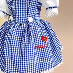 a blue and white gingham dress with red heart on the chest, says hello