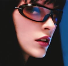 a woman wearing glasses and looking at something in the distance with her face slightly tilted to the side