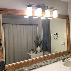 a bathroom with a large mirror and lights above the sink