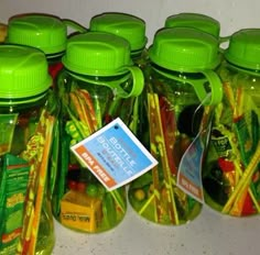 several green jars filled with different types of candy