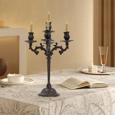 a candelabra is sitting on a table with two cups and saucers