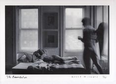 an old black and white photo of a naked woman laying on a bed next to a man