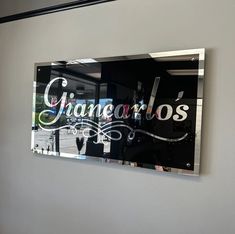 a glass sign hanging on the side of a wall next to a window that says chanaro's