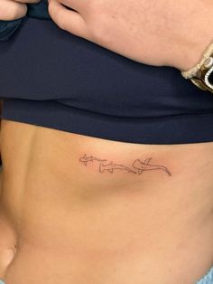 a woman's stomach with a small tattoo on the lower part of her belly