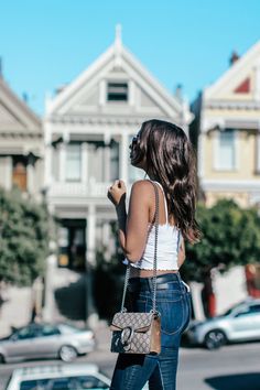 a woman is walking down the street with her hand in her pocket