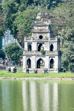 an old building sitting on the side of a lake