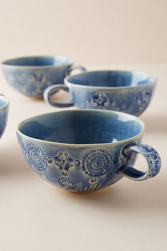 four blue cups sitting on top of a table