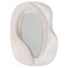 a white sculpture with a mirror in it