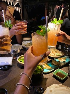 people sitting at a table with drinks and food