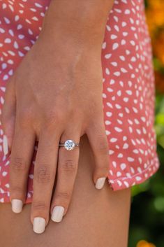 a close up of a person's hand with a diamond ring on their finger