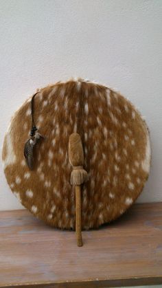 a stuffed animal is sitting on top of a wooden table next to a white wall