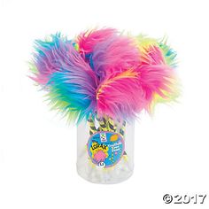 colorful feathers in a clear vase on a white background