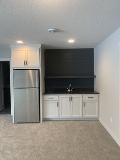 an empty kitchen with white cabinets and black counter tops is seen in this image from the doorway