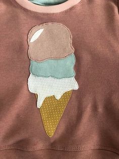 an ice cream cone embroidered onto a brown shirt