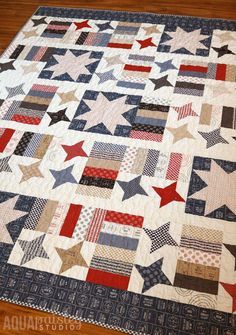 a quilted table topper with red, white and blue stars in the center