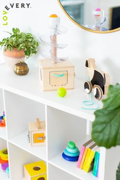 a white shelf topped with toys and a mirror